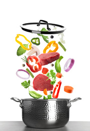 Image of Pot and fresh ingredients for soup on white background