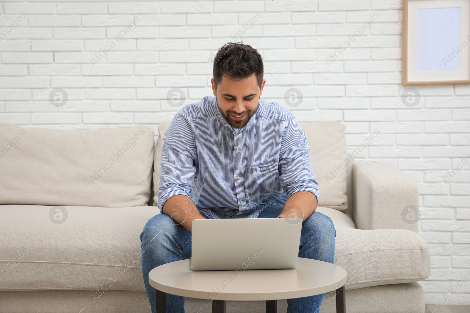 Photo of Man using laptop for online shopping at home