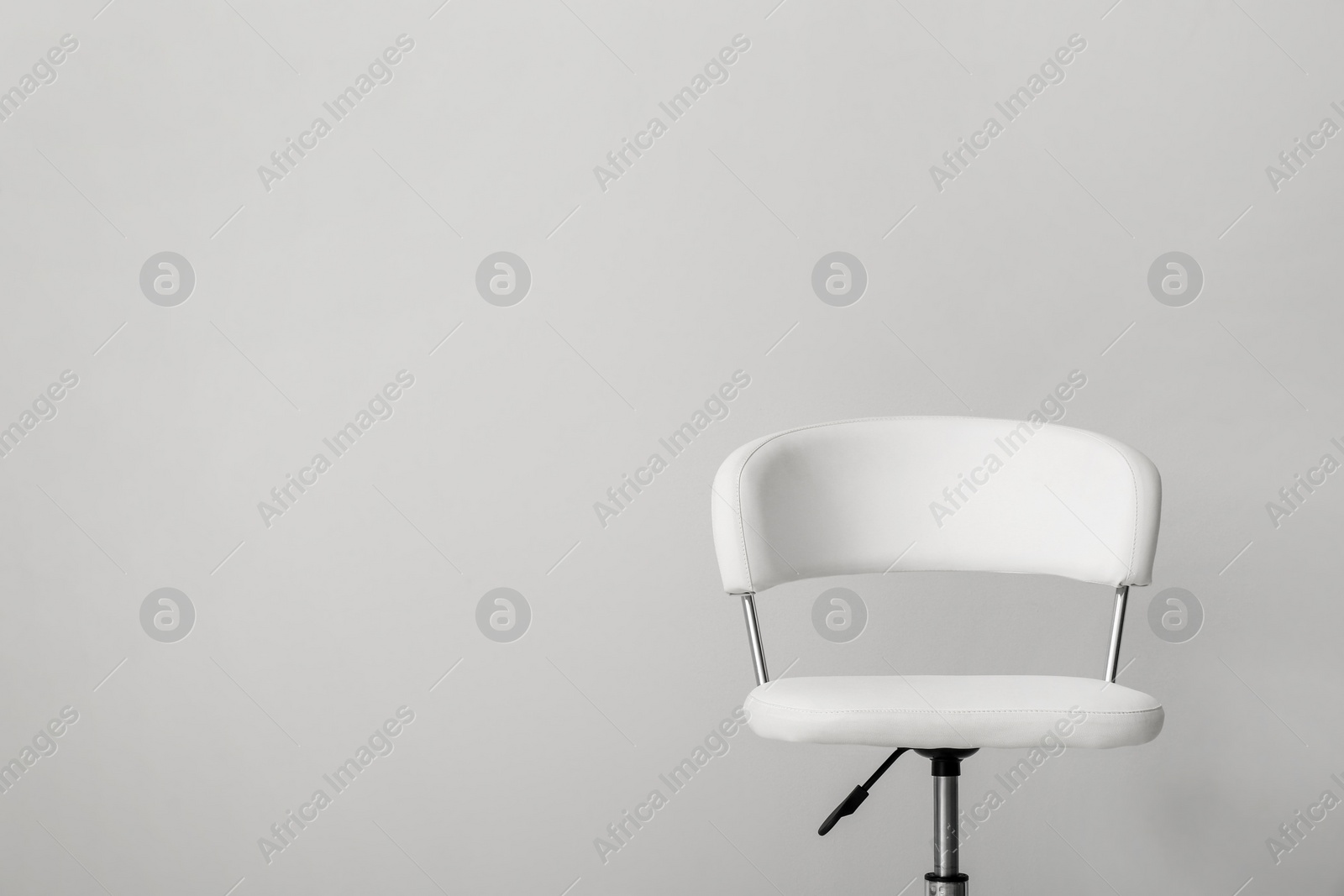 Photo of Comfortable office chair on light background. Space for text