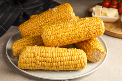 Delicious boiled corn with salt on table