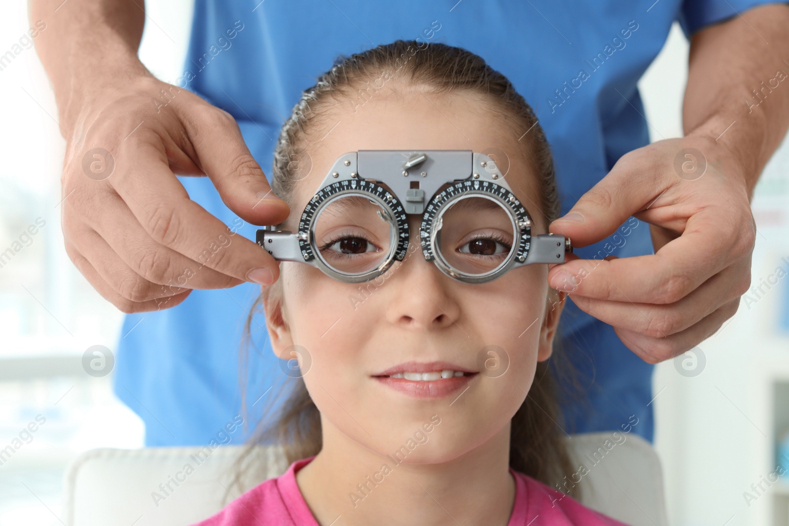 Photo of Ophthalmologist examining little girl in clinic