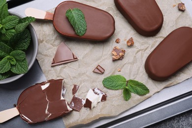 Photo of Glazed ice cream bars, fresh mint and chocolate on baking tray, flat lay