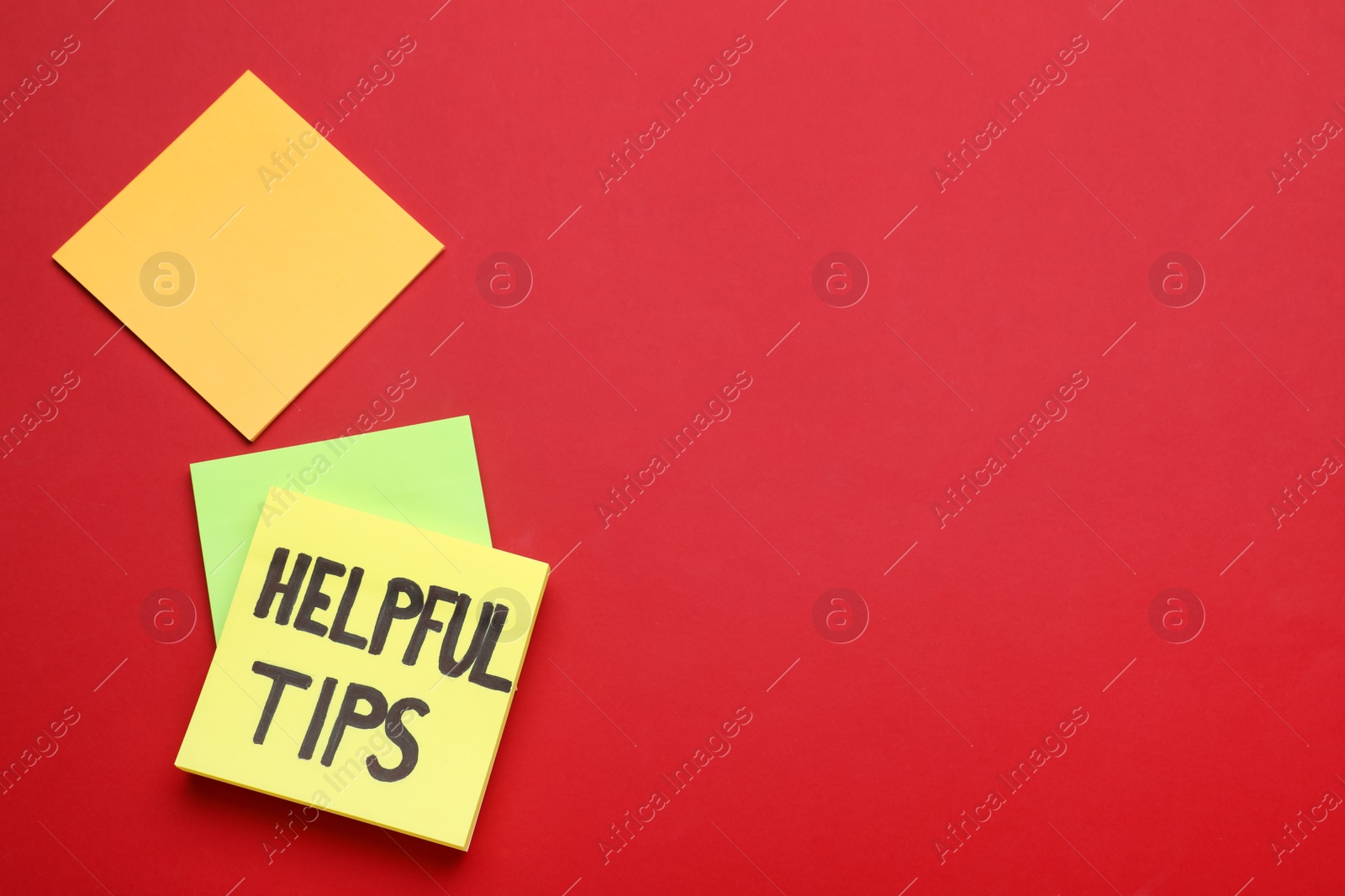 Photo of Paper note with phrase Helpful Tips on red background, top view. Space for text
