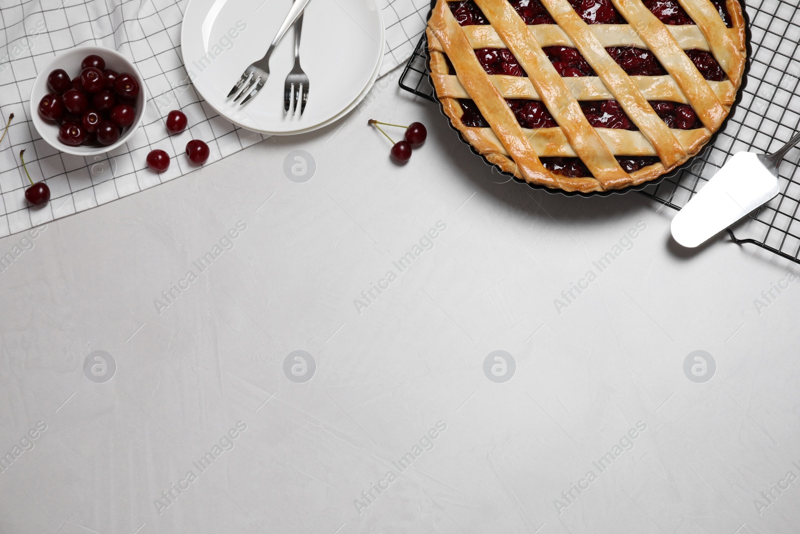 Photo of Flat lay composition with tasty cherry pie on light grey table. Space for text