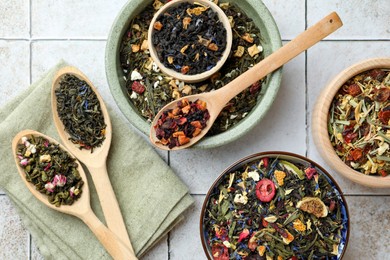 Photo of Many different herbal teas on white tiled surface, flat lay