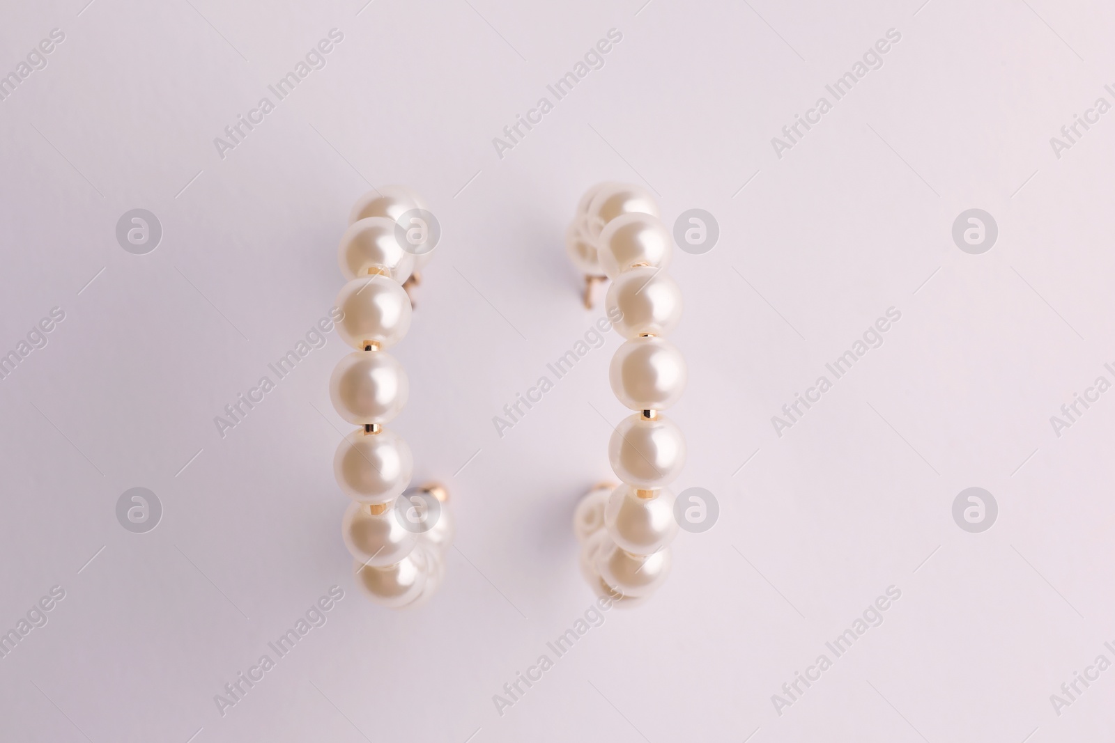 Photo of Elegant pearl earrings isolated on white, top view