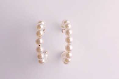 Elegant pearl earrings isolated on white, top view