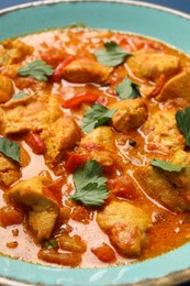 Photo of Delicious chicken curry with parsley in plate, closeup