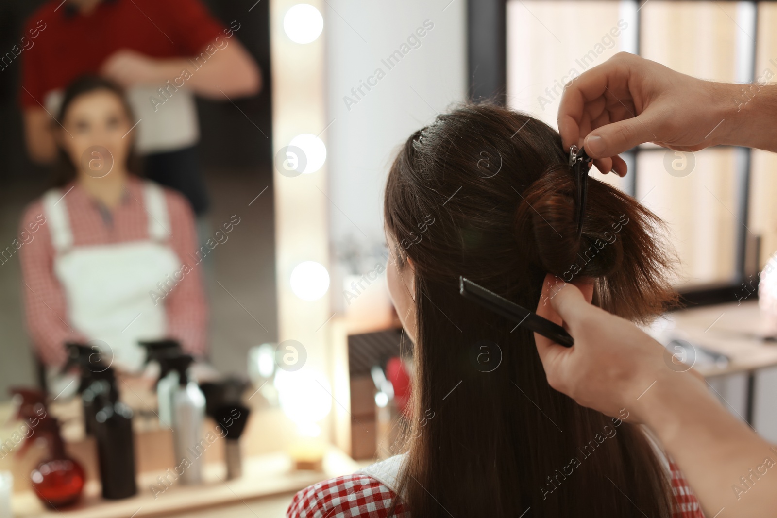 Photo of Professional hairdresser working with client in beauty salon