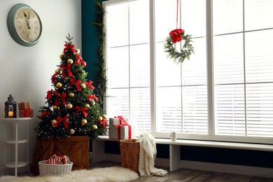 Stylish room interior with decorated Christmas tree