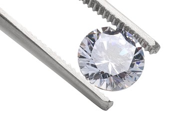 Photo of Tweezers with beautiful shiny diamond isolated on white