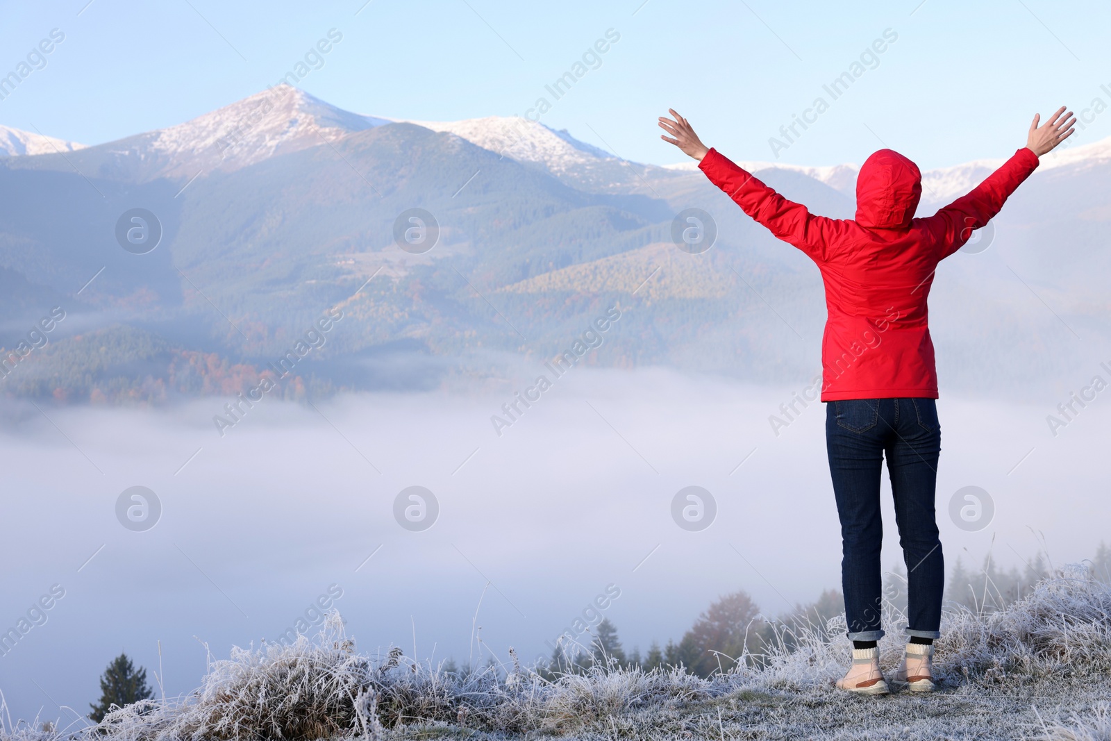 Photo of Woman admiring mountain landscape, back view. Freedom concept