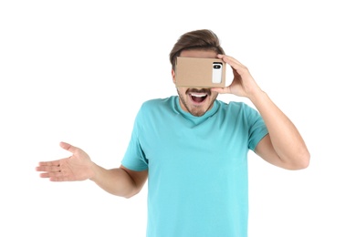 Young man using cardboard virtual reality headset, isolated on white