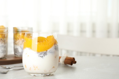Photo of Tasty peach dessert with yogurt and chia seeds on light table. Space for text