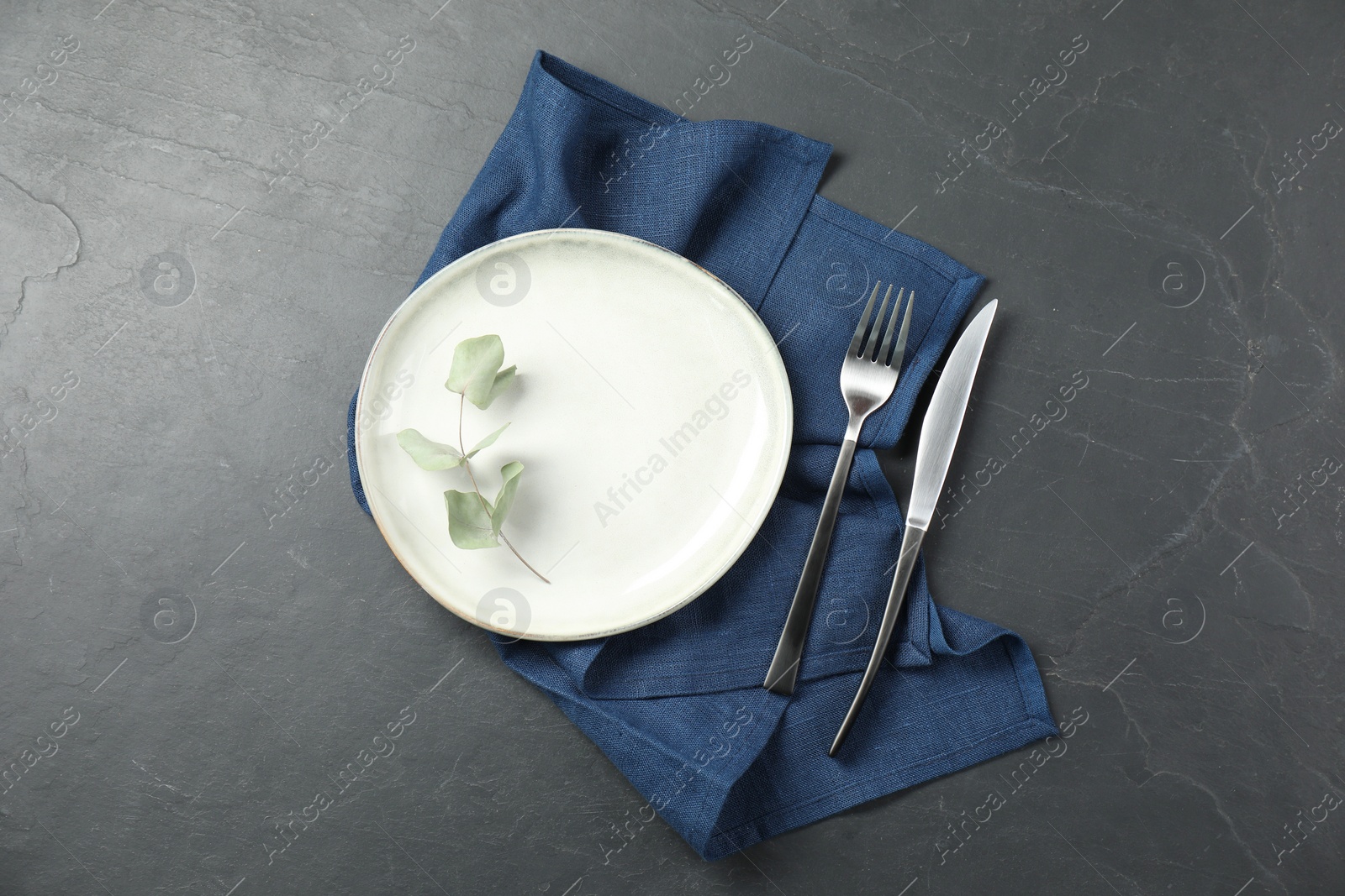 Photo of Stylish setting with elegant cutlery on grey textured table, top view