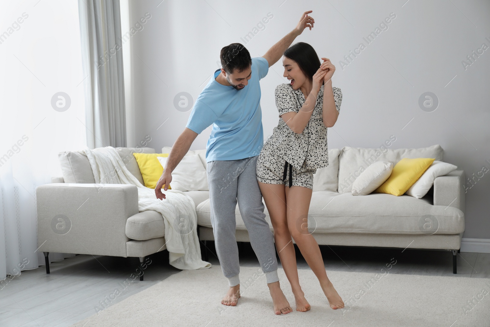 Photo of Happy couple in pajamas dancing at home