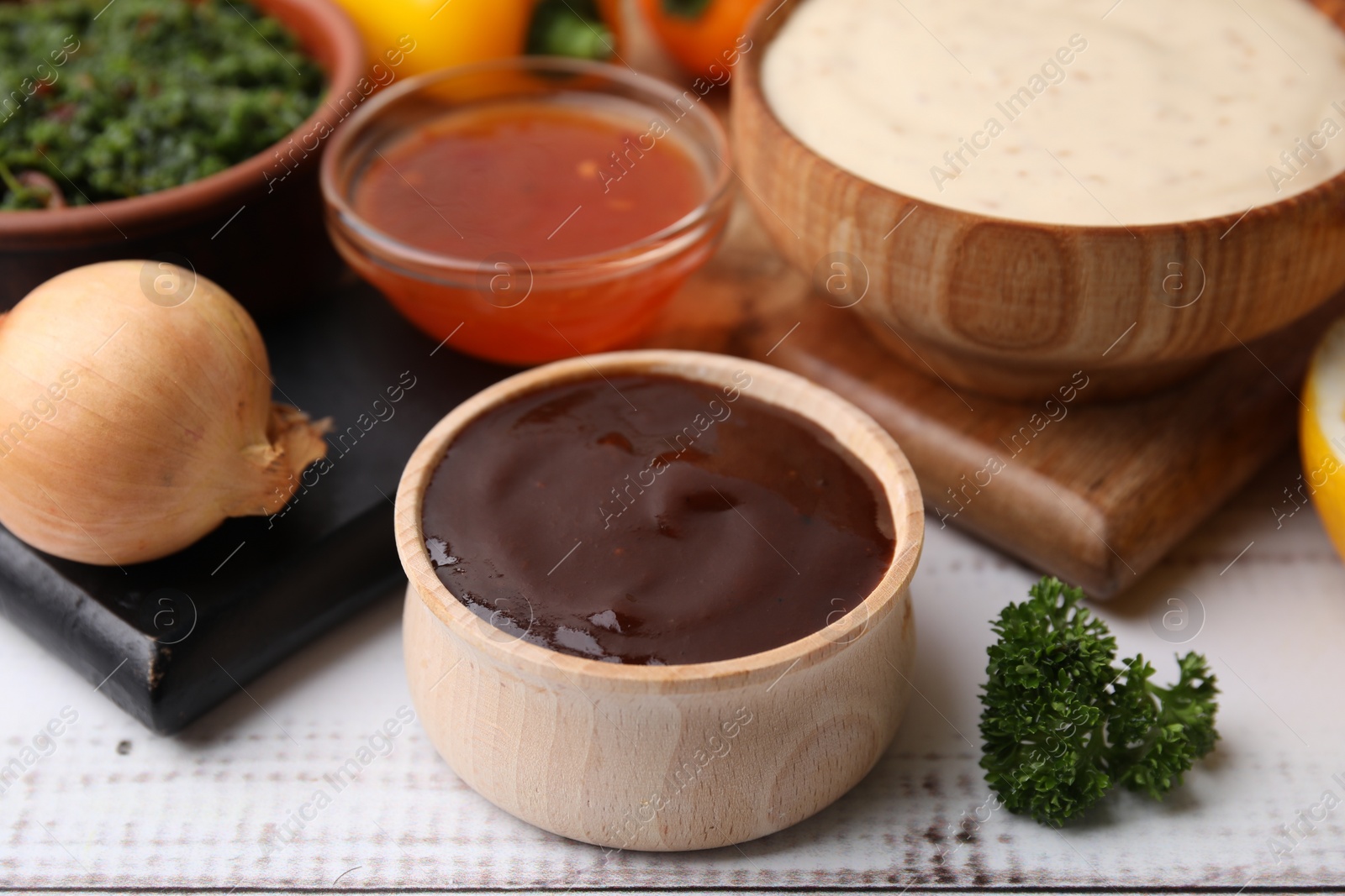 Photo of Fresh marinades in bowls and ingredients on white wooden table, closeup