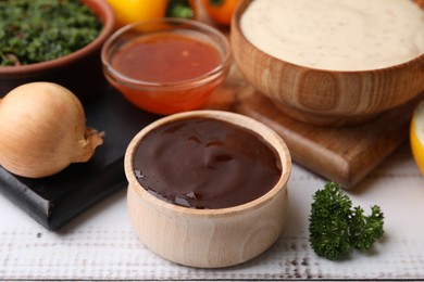 Photo of Fresh marinades in bowls and ingredients on white wooden table, closeup