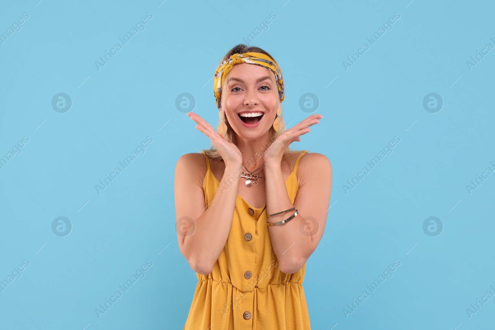 Photo of Portrait of happy hippie woman on light blue background