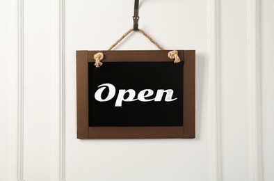 Image of Small chalk board with word Open on white wall