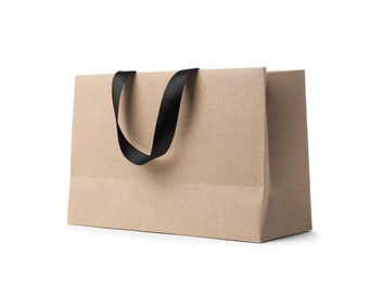 Photo of Paper shopping bag with ribbon handles on white background. Mockup for design