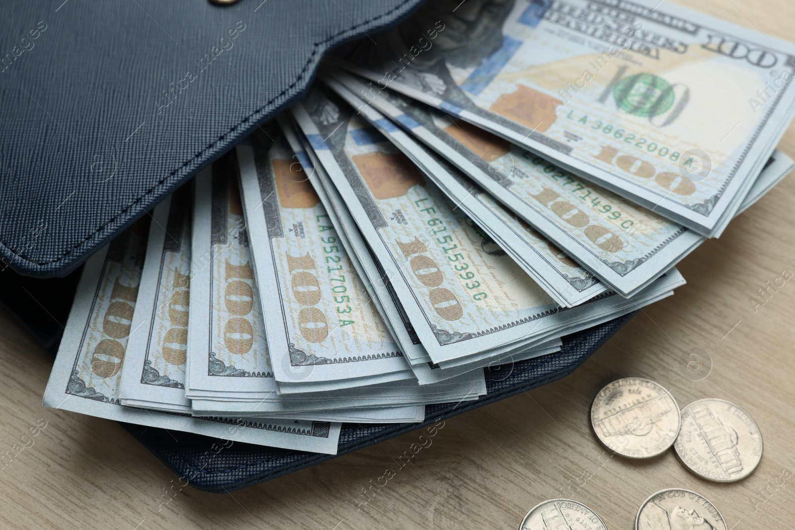 Photo of Dollar banknotes, coins and wallet on wooden table, closeup. Money exchange