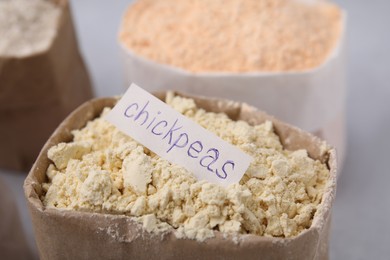 Photo of Sack with chickpea flour on blurred background, closeup