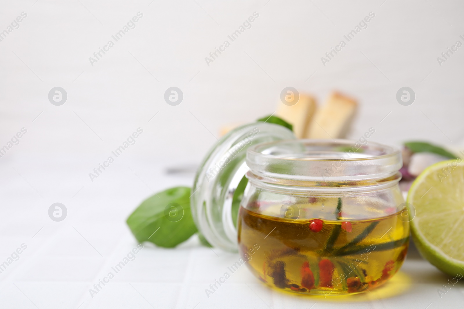 Photo of Tasty fish marinade in jar on light tiled table, closeup. Space for text