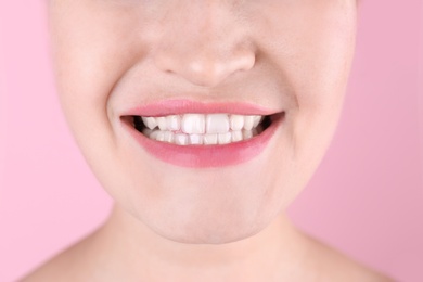 Photo of Young woman with beautiful smile on color background, closeup