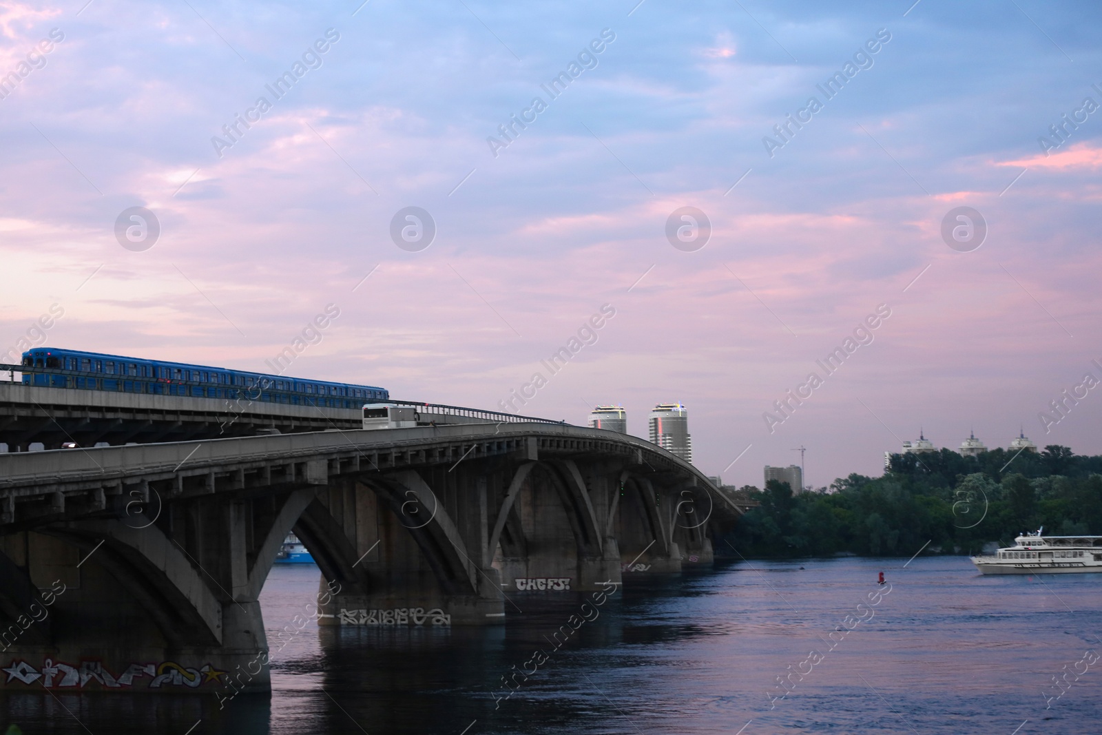 Photo of KYIV, UKRAINE - MAY 23, 2019: Beautiful view of Metro bridge over Dnipro river in evening