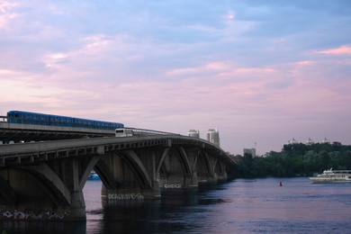 Photo of KYIV, UKRAINE - MAY 23, 2019: Beautiful view of Metro bridge over Dnipro river in evening