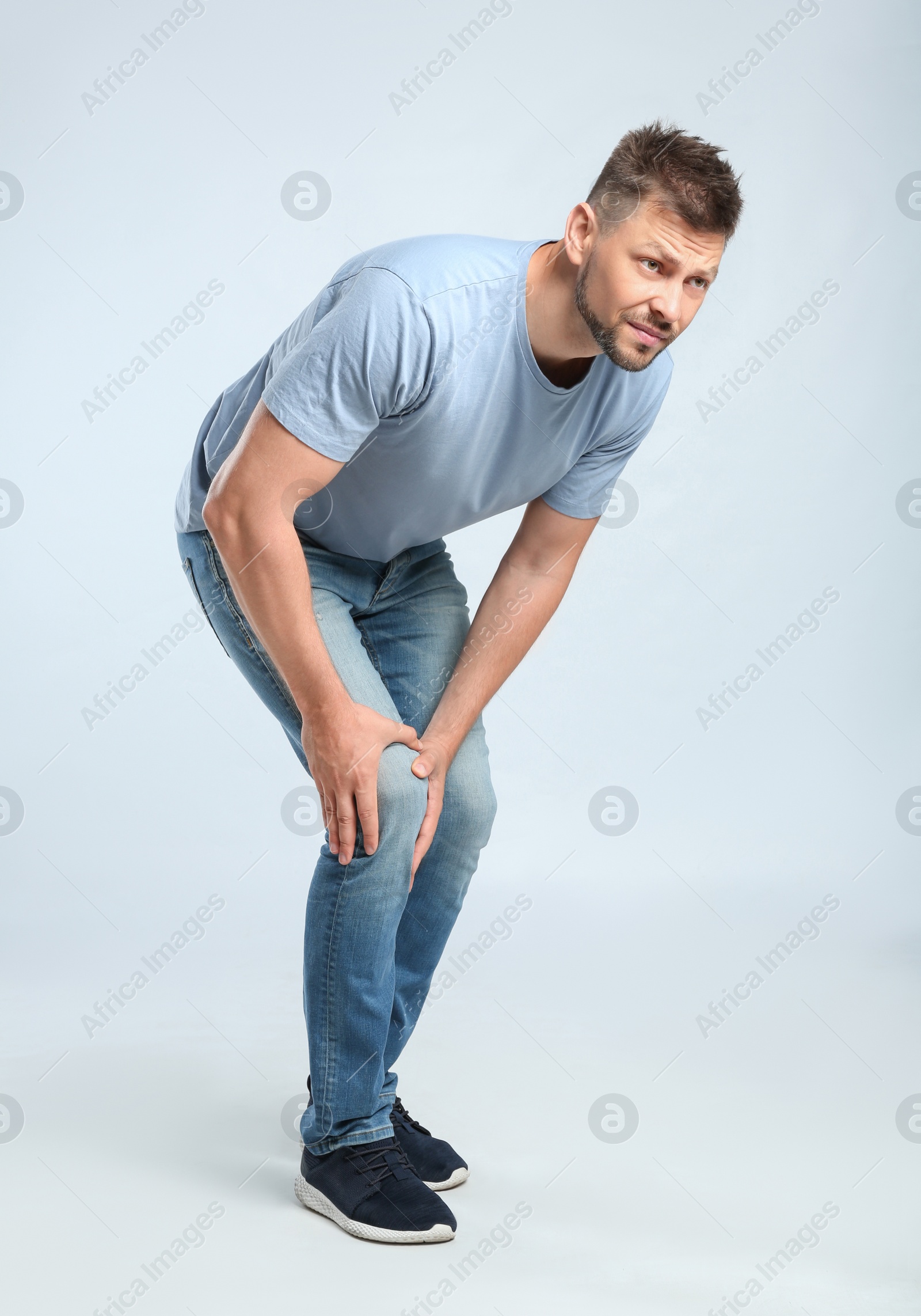 Photo of Full length portrait of man having knee problems on grey background