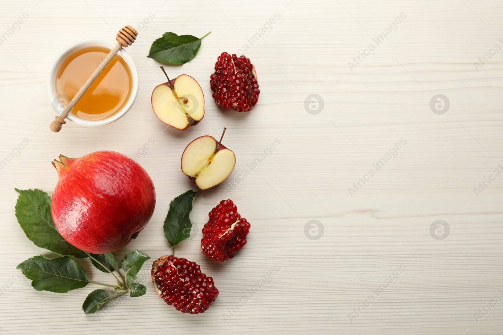 Photo of Flat lay composition with Rosh Hashanah holiday attributes on white wooden table. Space for text