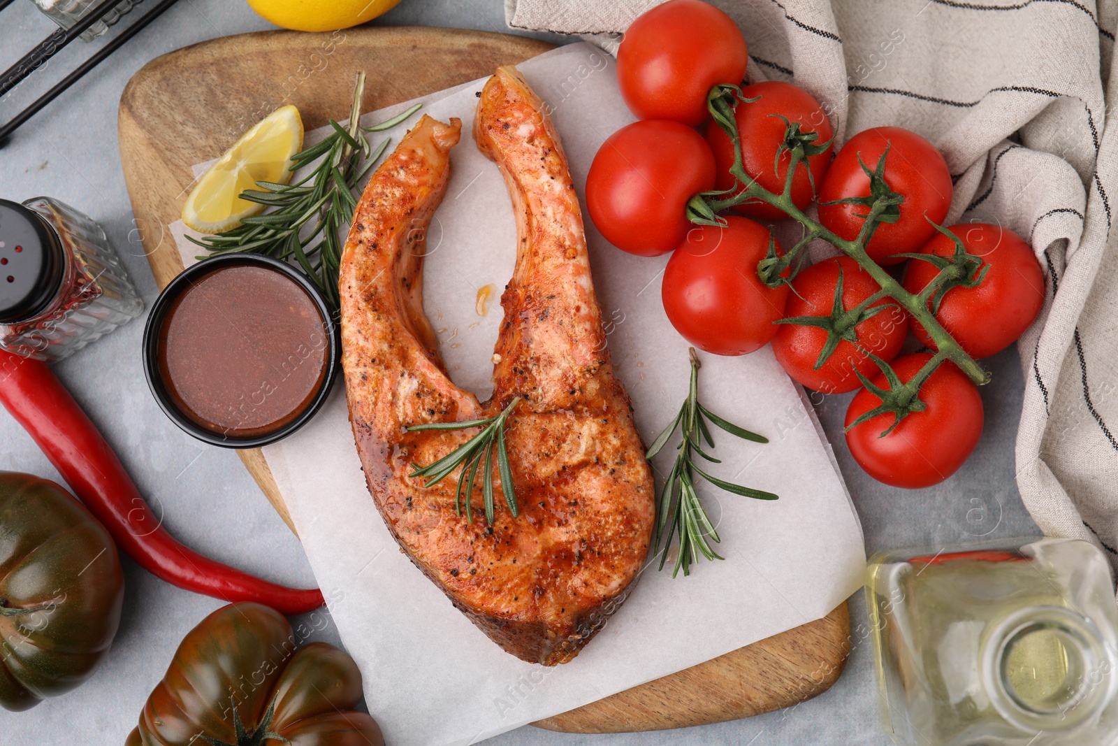 Photo of Fresh marinade, cooked fish and other products on grey table, flat lay