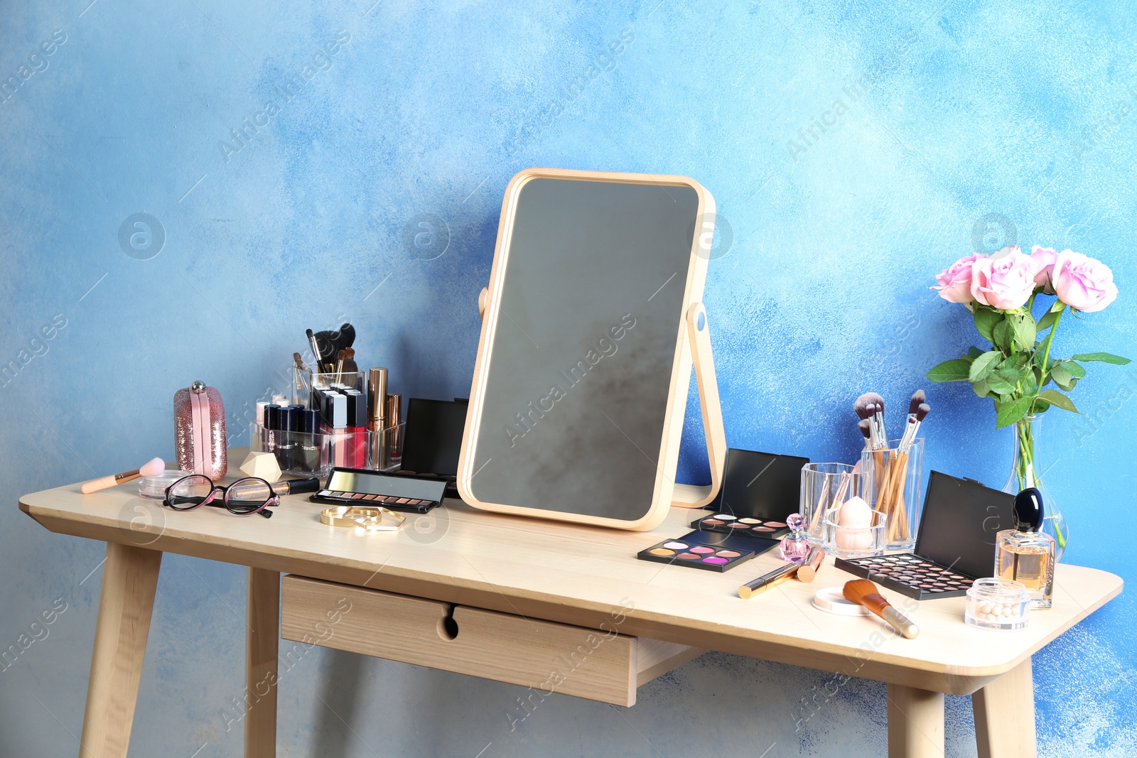 Photo of Dressing table with beauty accessories near color wall in room