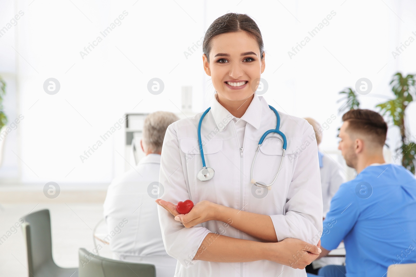 Photo of Female doctor holding small heart in clinic. Cardiology center