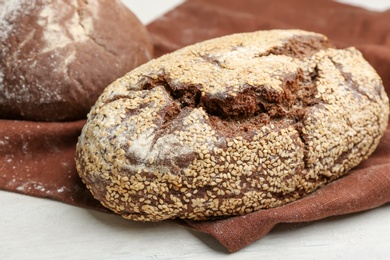 Tasty freshly baked bread on white wooden table, closeup