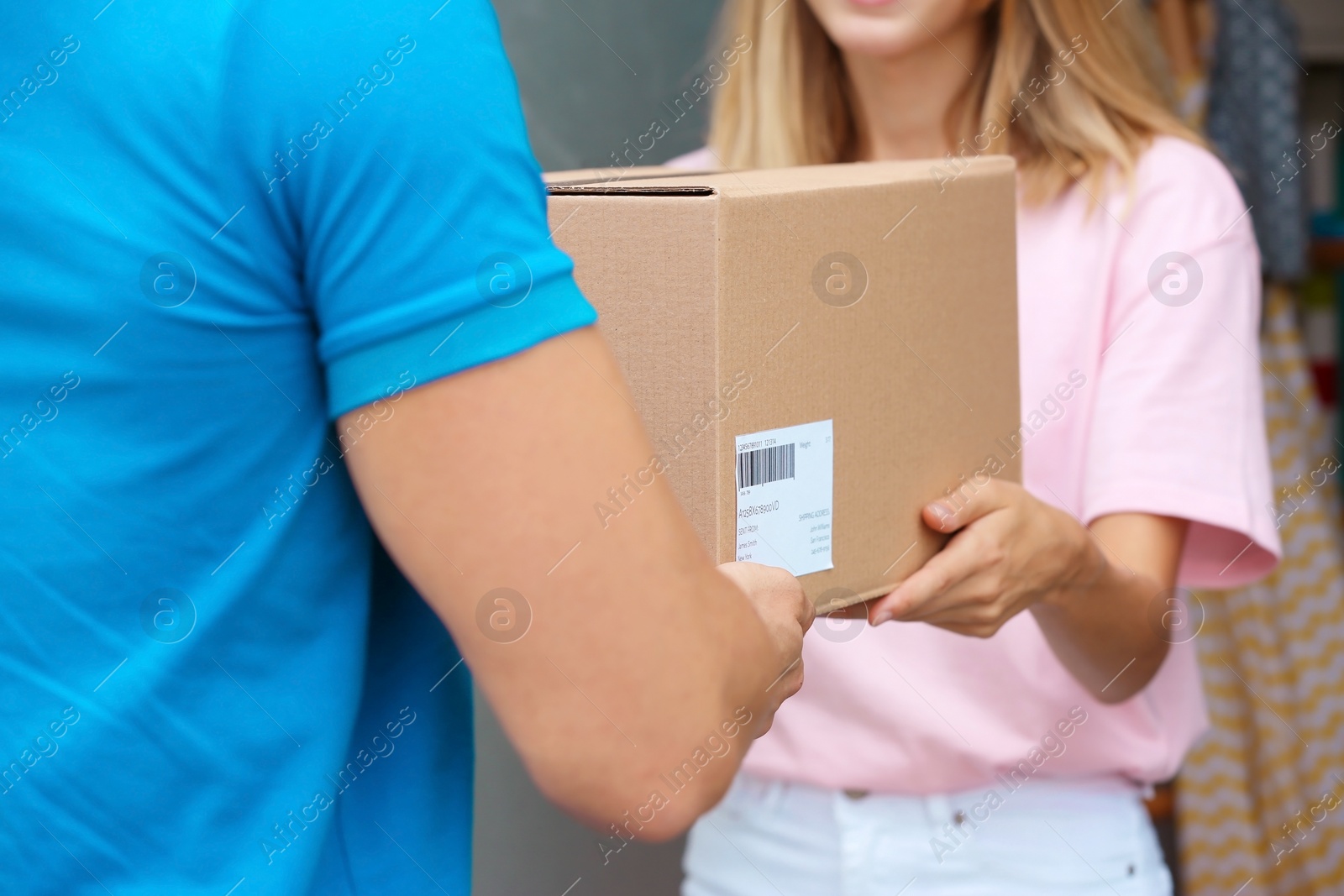 Photo of Woman receiving parcel from delivery service courier on doorstep
