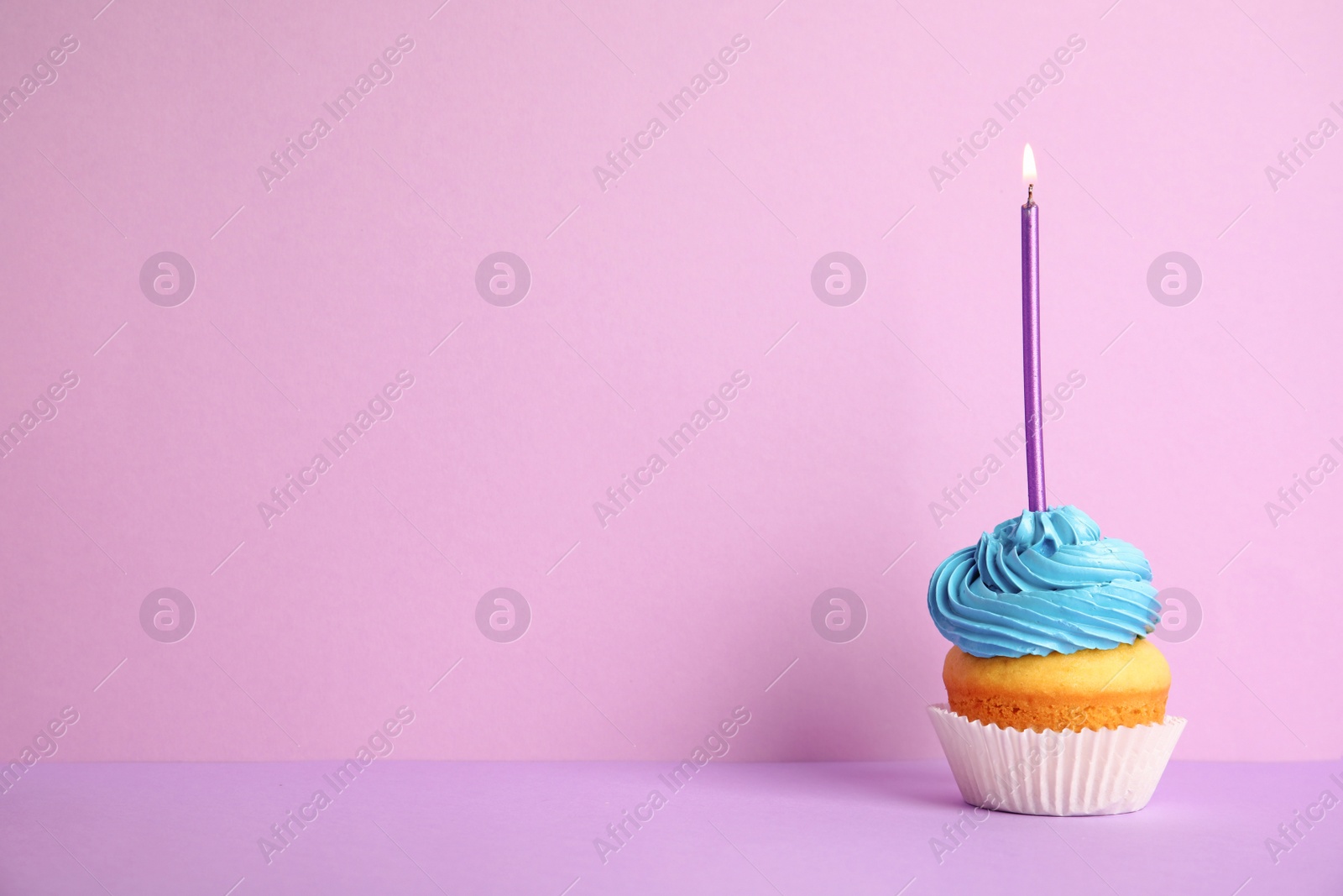 Photo of Birthday cupcake with candle on violet background, space for text