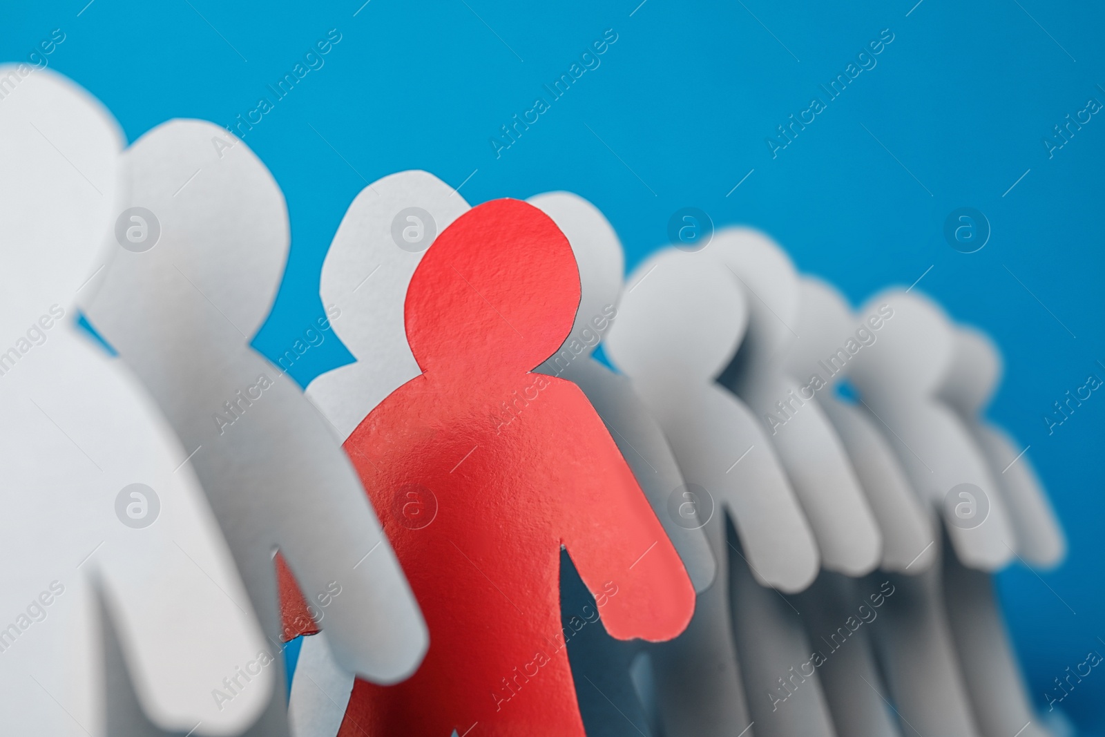 Photo of Paper people and different one on color background