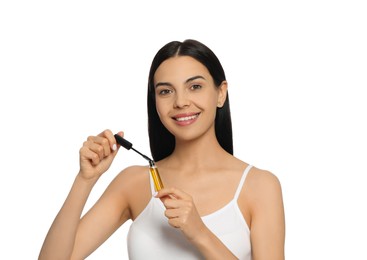 Photo of Young woman with eyelash oil on white background