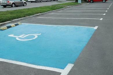 Photo of Car parking lot with handicapped symbol outdoors