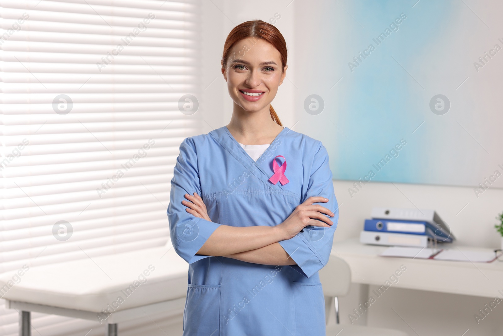 Photo of Mammologist with pink ribbon in hospital. Breast cancer awareness