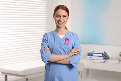 Mammologist with pink ribbon in hospital. Breast cancer awareness