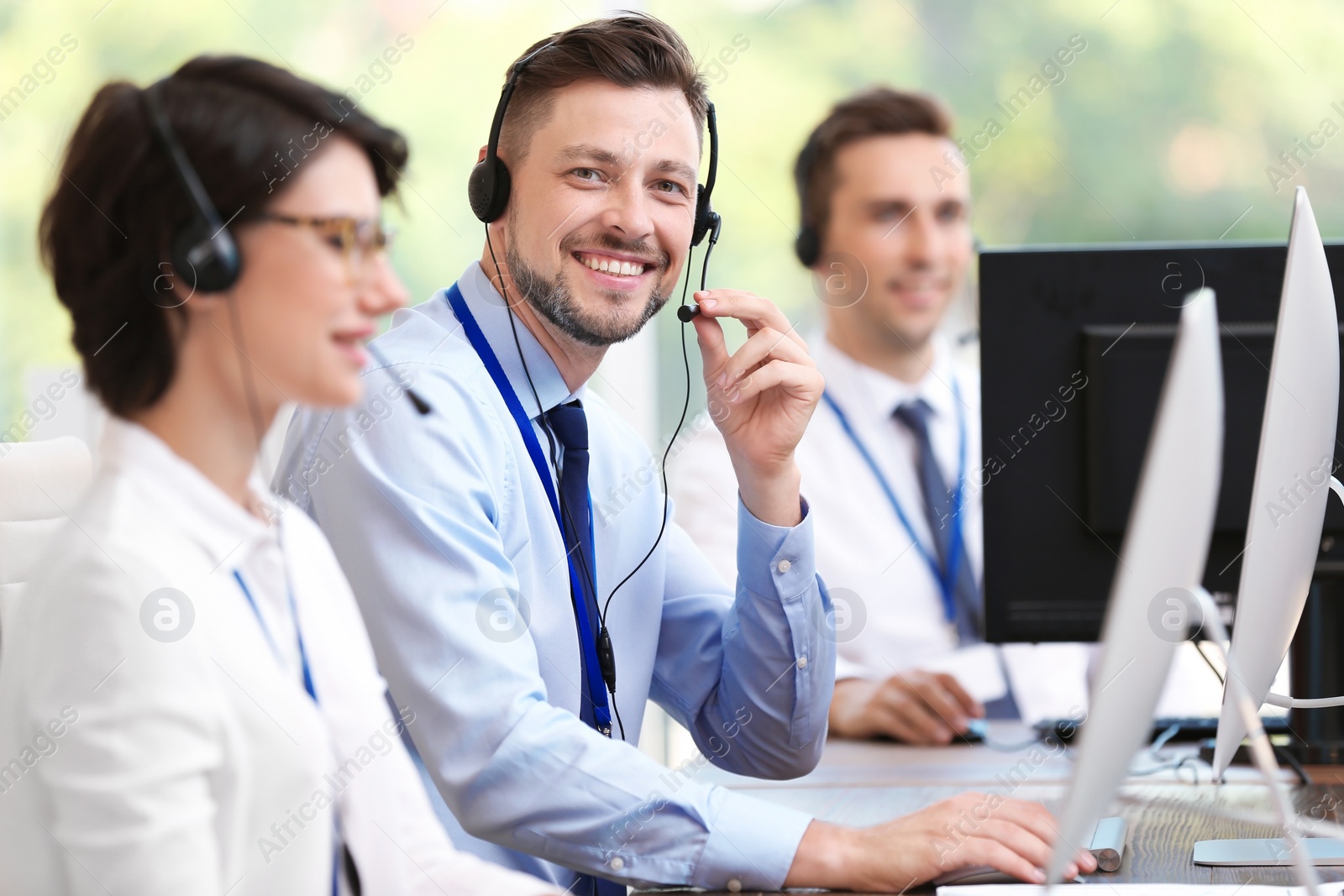 Photo of Technical support operators with headsets at workplace