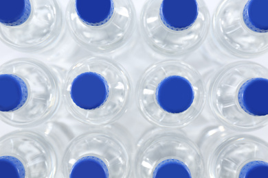 Photo of Plastic bottles with pure water as background, top view