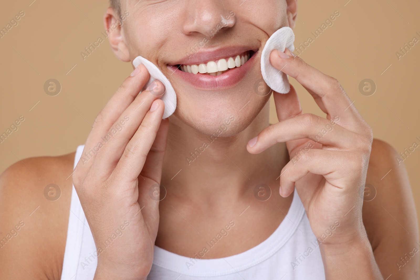 Photo of Man with cotton pads on beige background, closeup