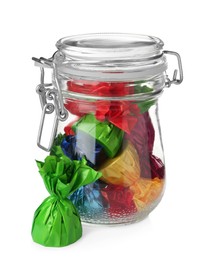 Glass jar with candies in colorful wrappers isolated on white