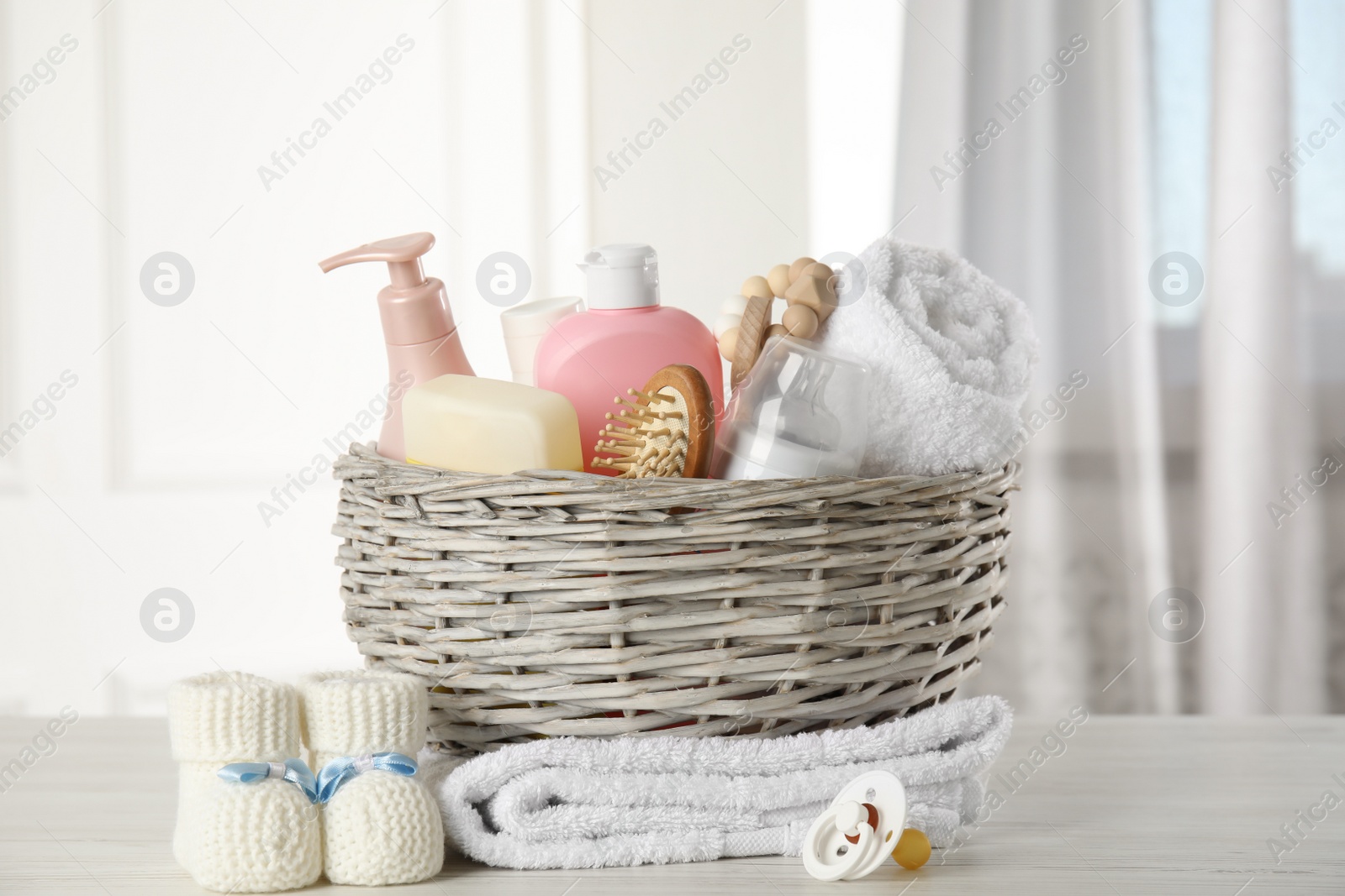 Photo of Baby booties and accessories on white wooden table indoors