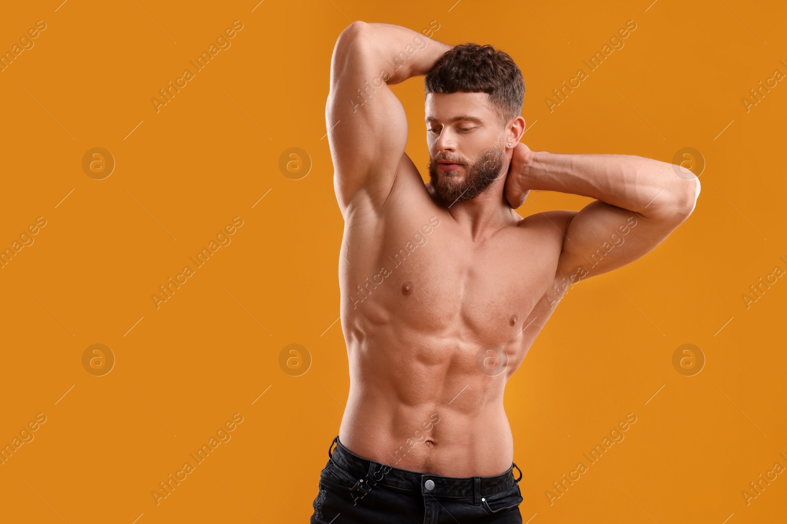 Photo of Handsome muscular man on orange background. Sexy body